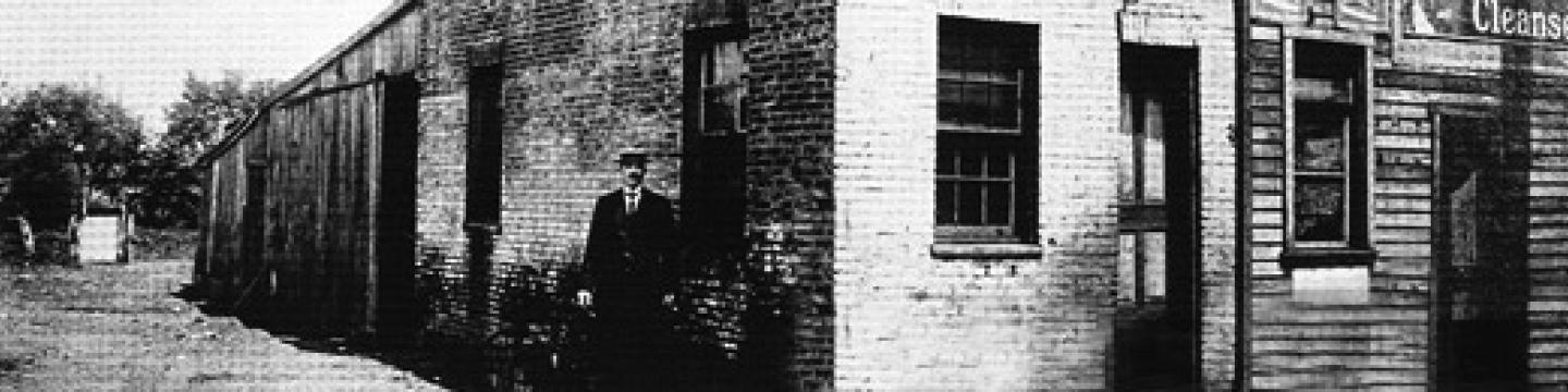 Crandal Mackey standing in front of Charles Knoxville’s Sunday Bar. A photo from his 1903 campaign for Commonwealth Attorney. (Credit: RosslynVA.org)